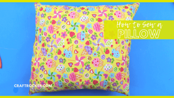 Close Up of Colorful Pillow on Blue Background with text overlay - How to Sew a Pillow - Craft Rocker