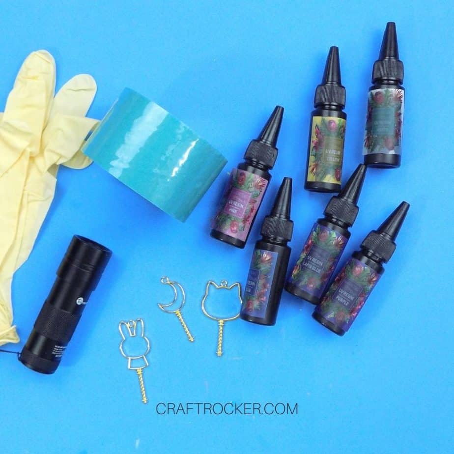 UV Resin Bottles next to Metal Charms and Tools - Craft Rocker