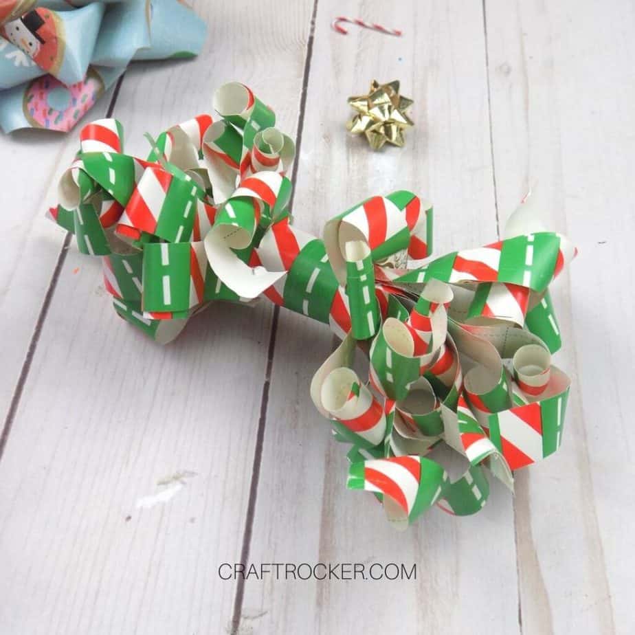 Close Up of Curled Wrapping Paper Bow on Wood Background - Craft Rocker