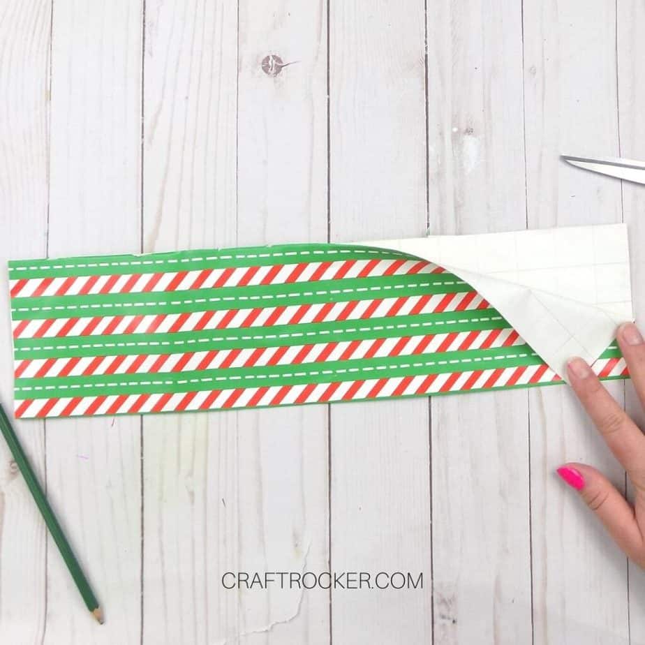 Hand Holding Back Corner of Folded Striped Piece of Wrapping Paper - Craft Rocker