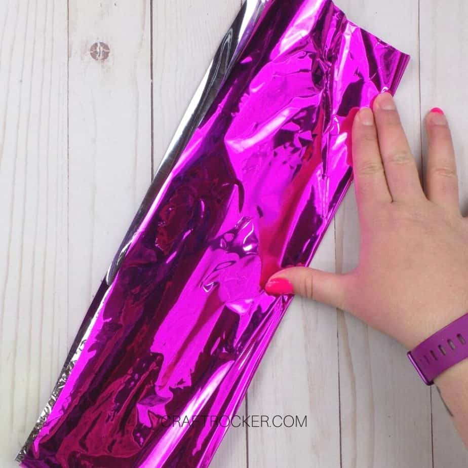 Hand Holding Folded Piece of Pink Foil Paper - Craft Rocker