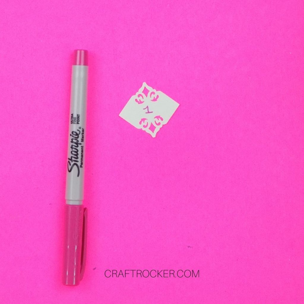 Sharpie Marker Next to Decorative Square with the Number 1 Written on It - Craft Rocker