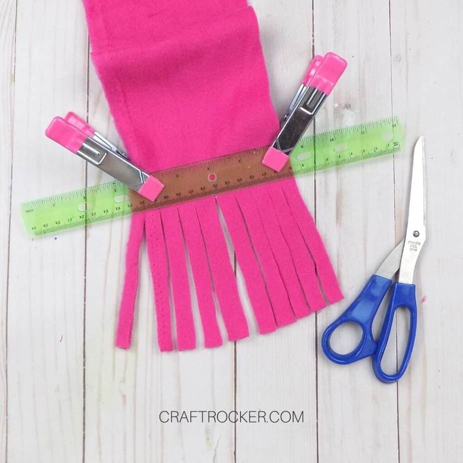 Close Up of Fringe Cut into Hot Pink Fleece next to Scissors - Craft Rocker