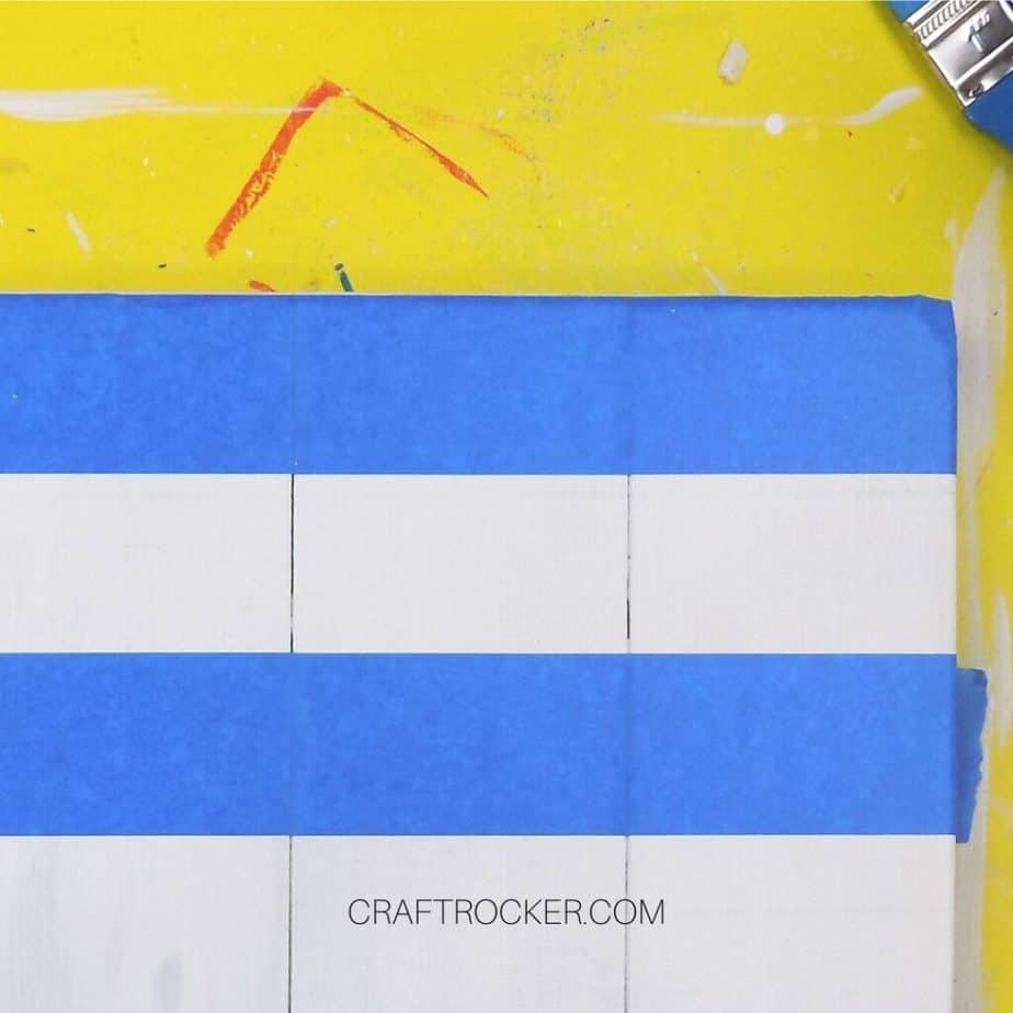 Close Up of Horizontal Lines of Blue Tape on White Pallet - Craft Rocker