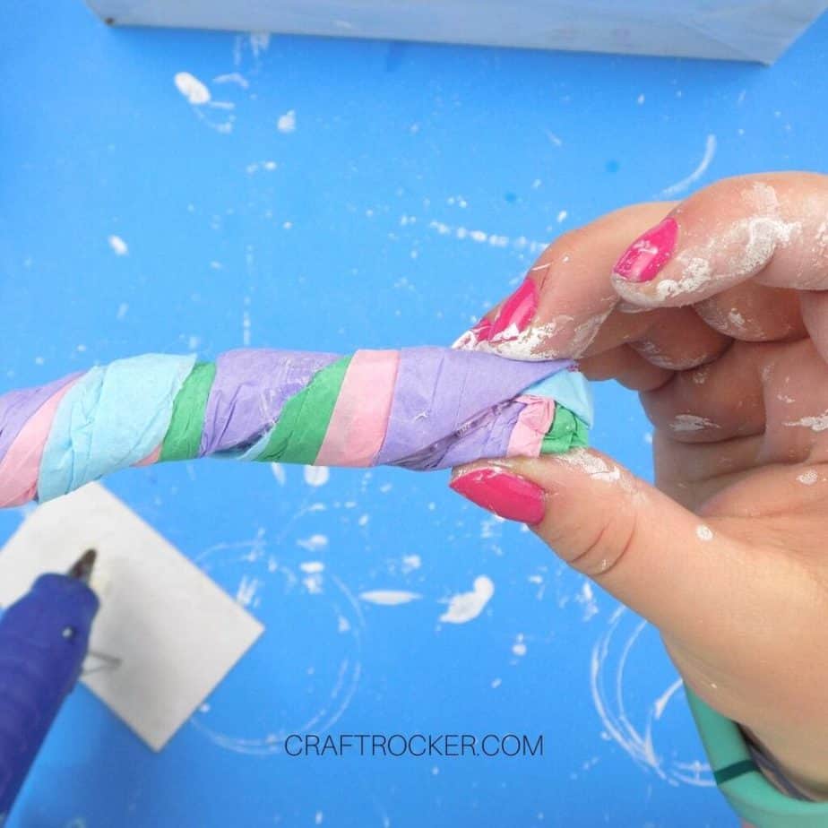 Hand Holding Rolled Pieces of Tissue Paper Twisted Together - Craft Rocker