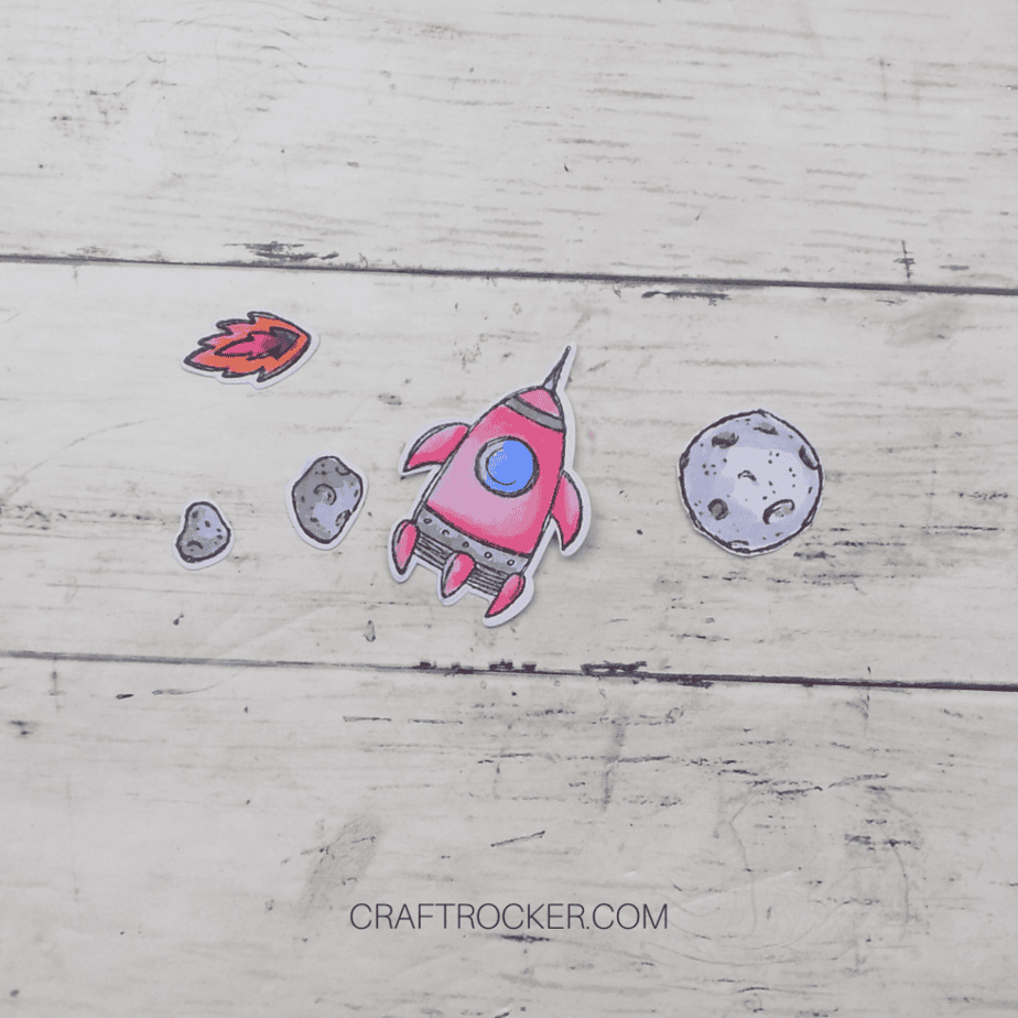 Close Up of Die Cut Space Items on Wood Background - Craft Rocker