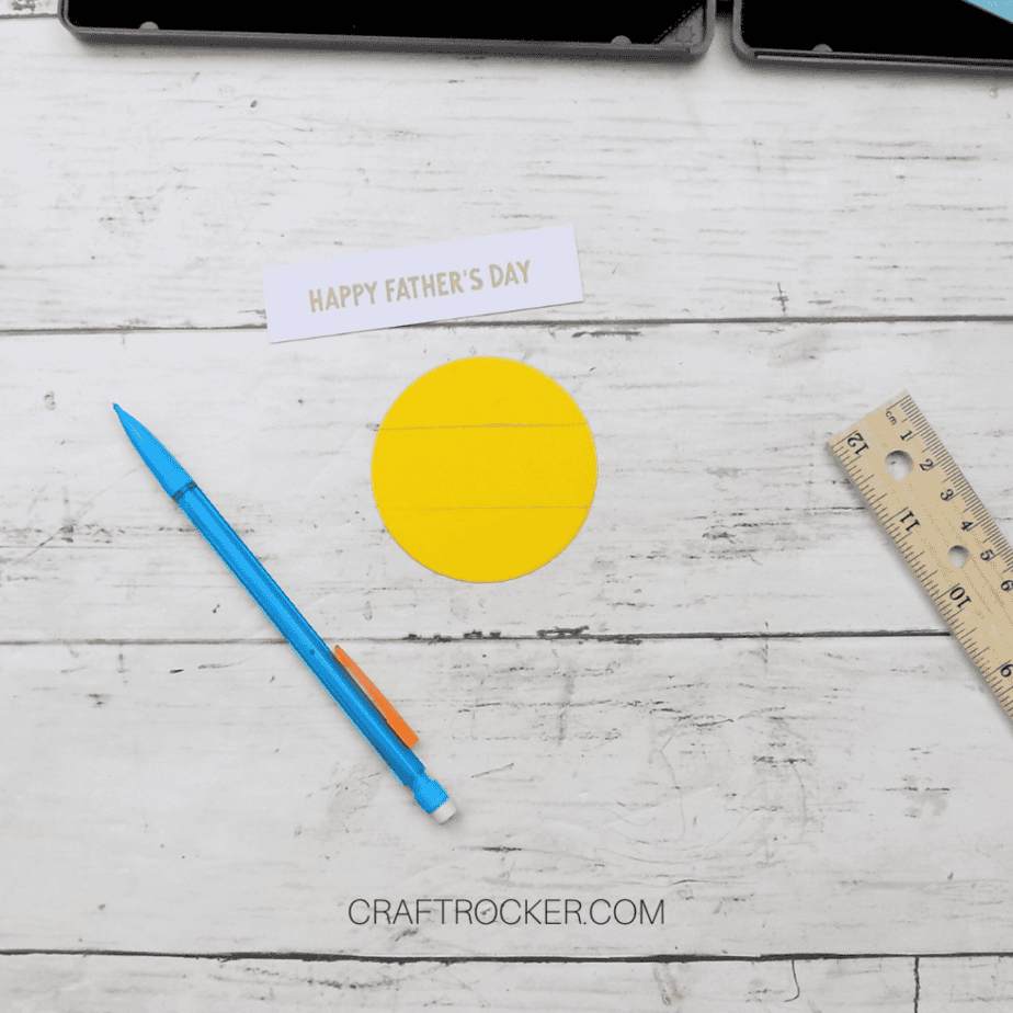 Happy Father's Day Stamped on White Strip of Paper next to Yellow Paper Circle with Pencil Lines Drawn on It - Craft Rocker