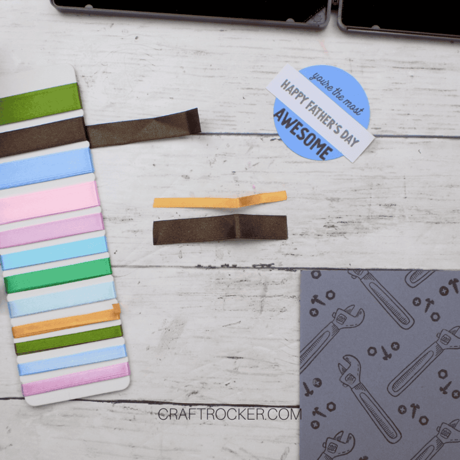 Strips of Tan and Brown Ribbon next to Ribbon Holder and Card Elements - Craft Rocker
