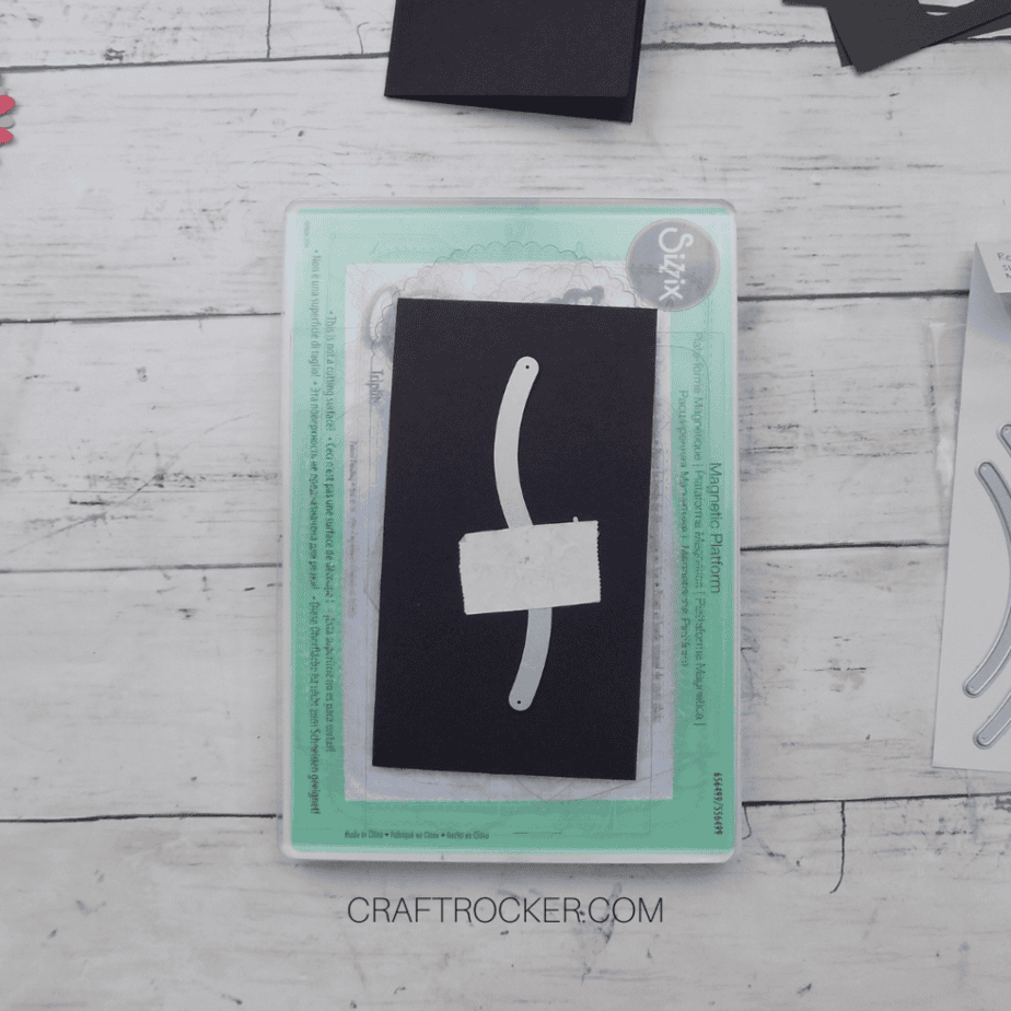 Wavy Line Die Taped to Piece of Black Cardstock on Sizzix Plates - Craft Rocker